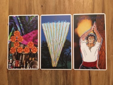 Image: 9 of pentacles, 10 of wands, and knight of swords. Further description in text.